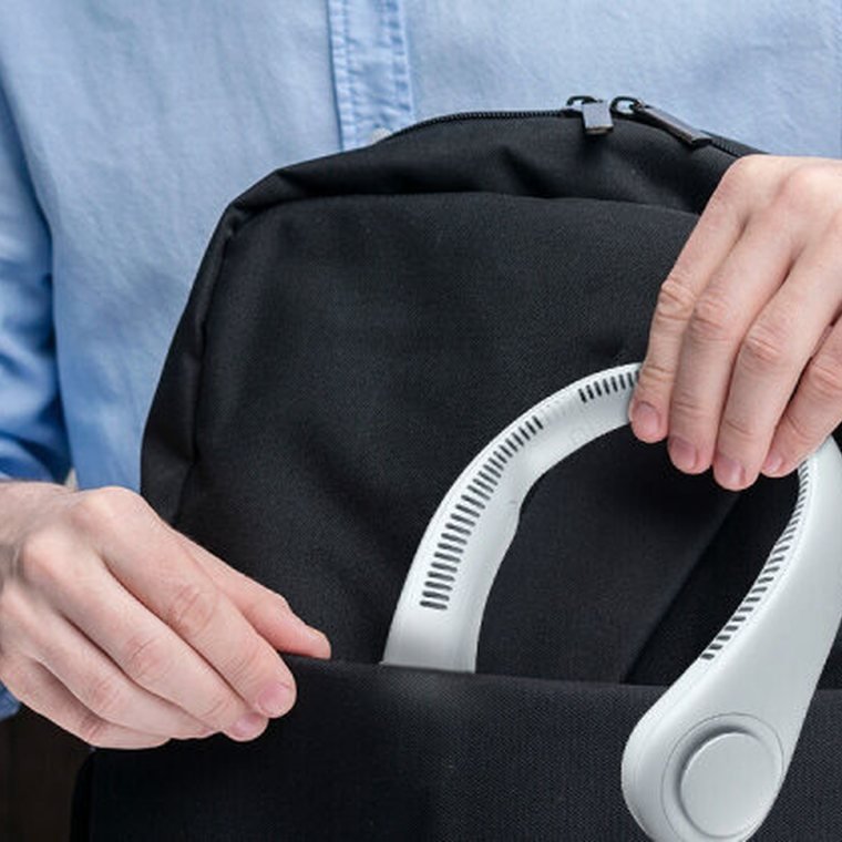 The FluxoFan neck fan being packed into a backpack